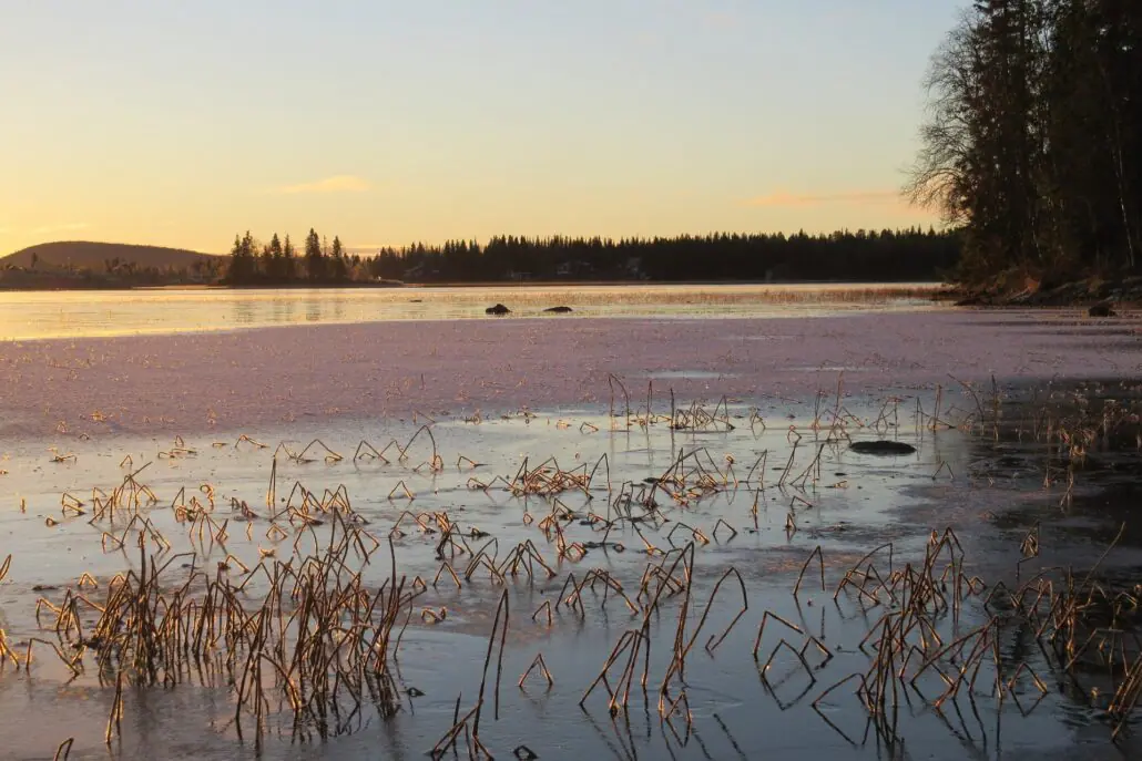Norrbotten 3 Untergehende Sonne über einem gefrorenem See in Norrboten, Schweden.